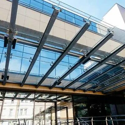 Glass canopy installation over entrance walkway in commercial property UK